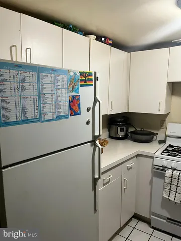 a kitchen with refrigerator and white cabinets