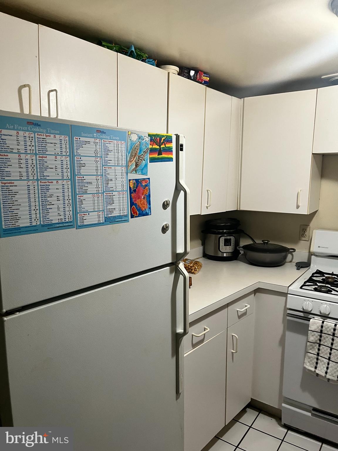 1239 Vermont Avenue Northwest, Unit 104 Washington, DC 20005 - Photo 16 of 30 a kitchen with refrigerator and white cabinets