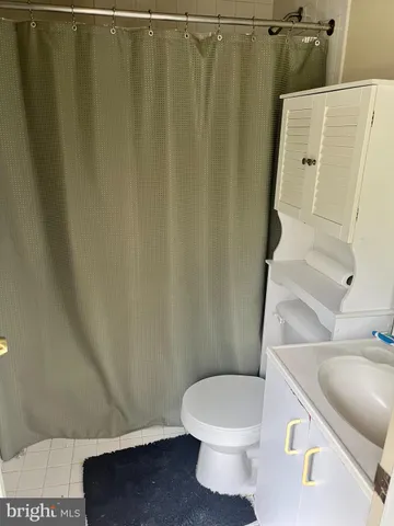 a white toilet sitting next to a shower