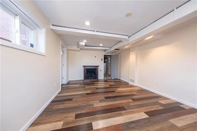 a view of empty room with wooden floor and fireplace