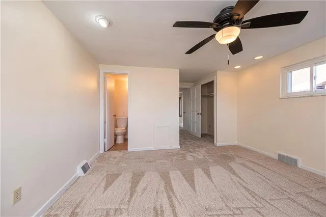 an empty room with a ceiling fan and a window