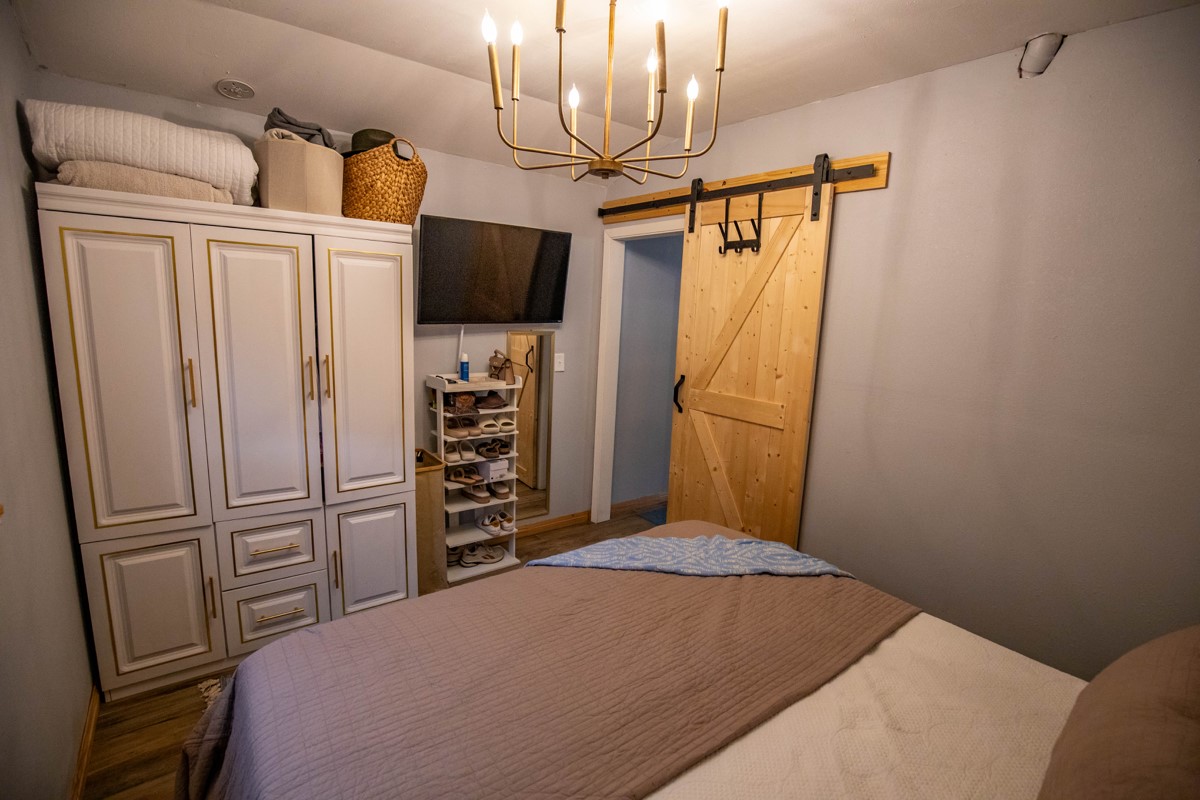 143 Harrison Road Beeville, TX 78102 - Photo 11 of 39 Bedroom featuring a barn door and a chandelier