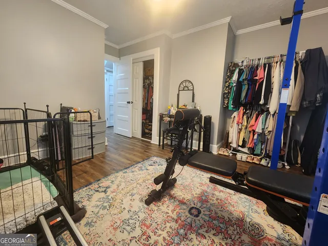 a bedroom with a bed rug and wooden floor