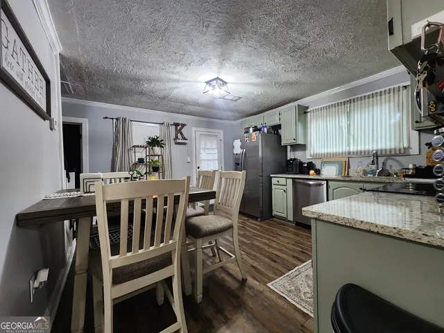 a kitchen with sink a refrigerator and chairs
