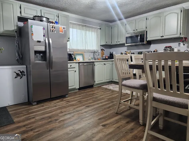 a kitchen with kitchen island a counter top space a sink stainless steel appliances and cabinets