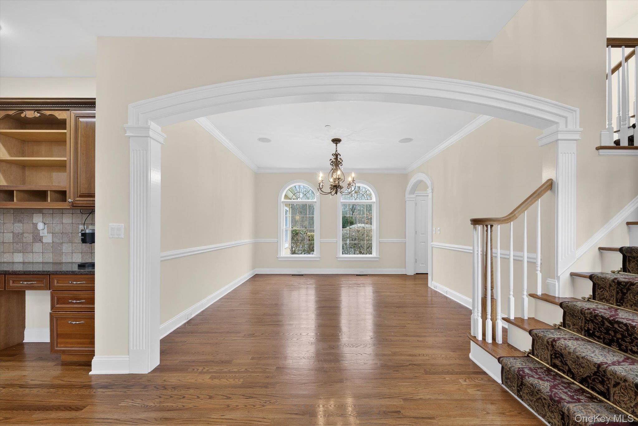 7 Farm Hollow Road New Windsor, NY 12553 - Photo 9 of 36 Unfurnished dining area with built in study area, arched walkways, dark wood-style flooring, ornamental molding, and a chandelier