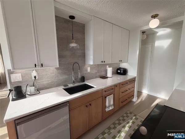 a kitchen with stainless steel appliances granite countertop a sink stove and cabinets