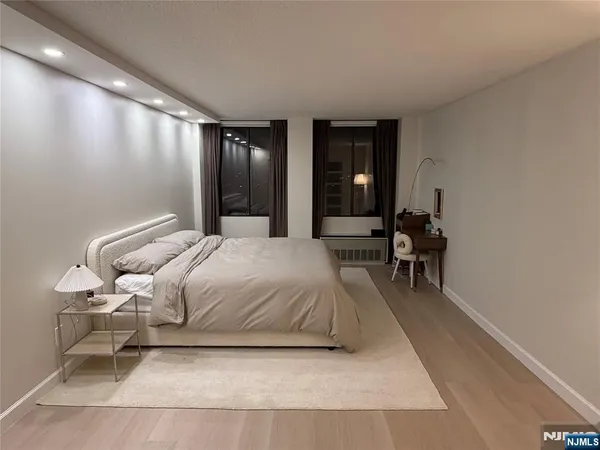 a bedroom with a bed and wooden floor