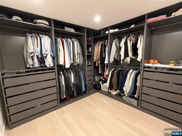 a view of walk in closet with clothes and shoes