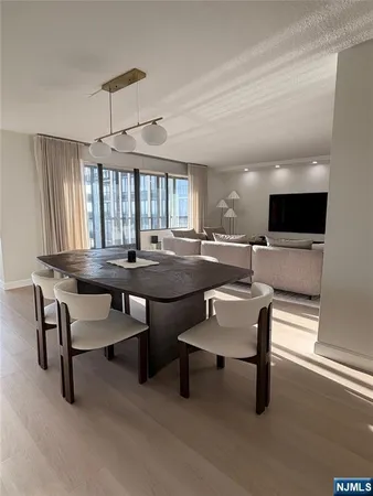 a kitchen with stainless steel appliances a sink a stove a microwave a refrigerator a cabinets and wooden floor