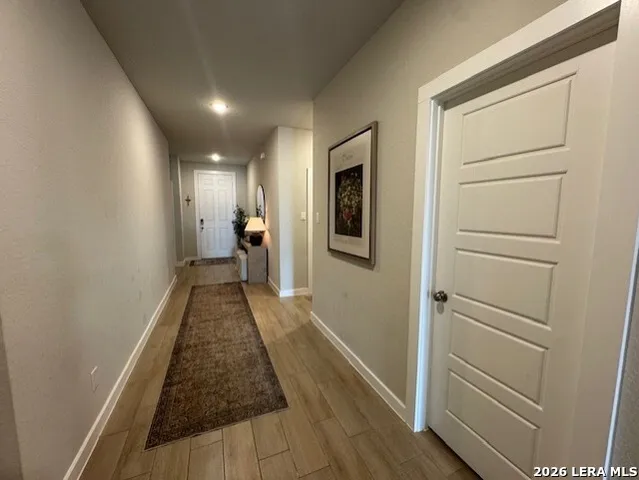 a view of a hallway with wooden floor and closet