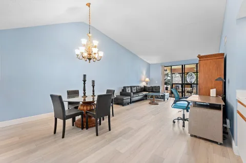 a view of a dining room with furniture a chandelier and wooden floor