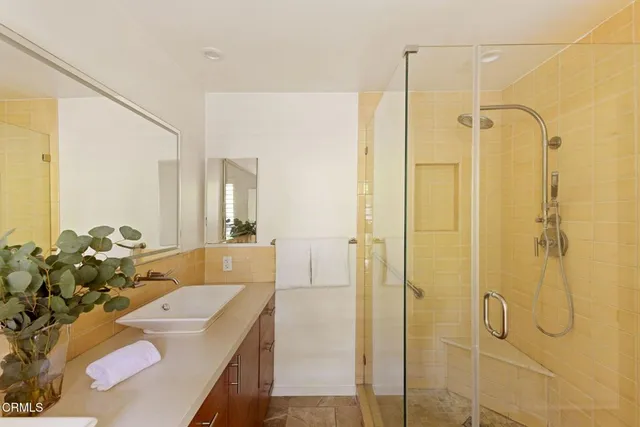 a bathroom with a granite countertop shower a sink and mirror