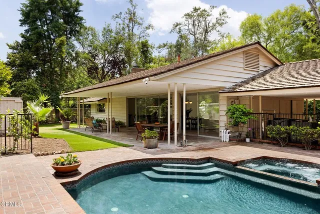 a view of a house with swimming pool and sitting area