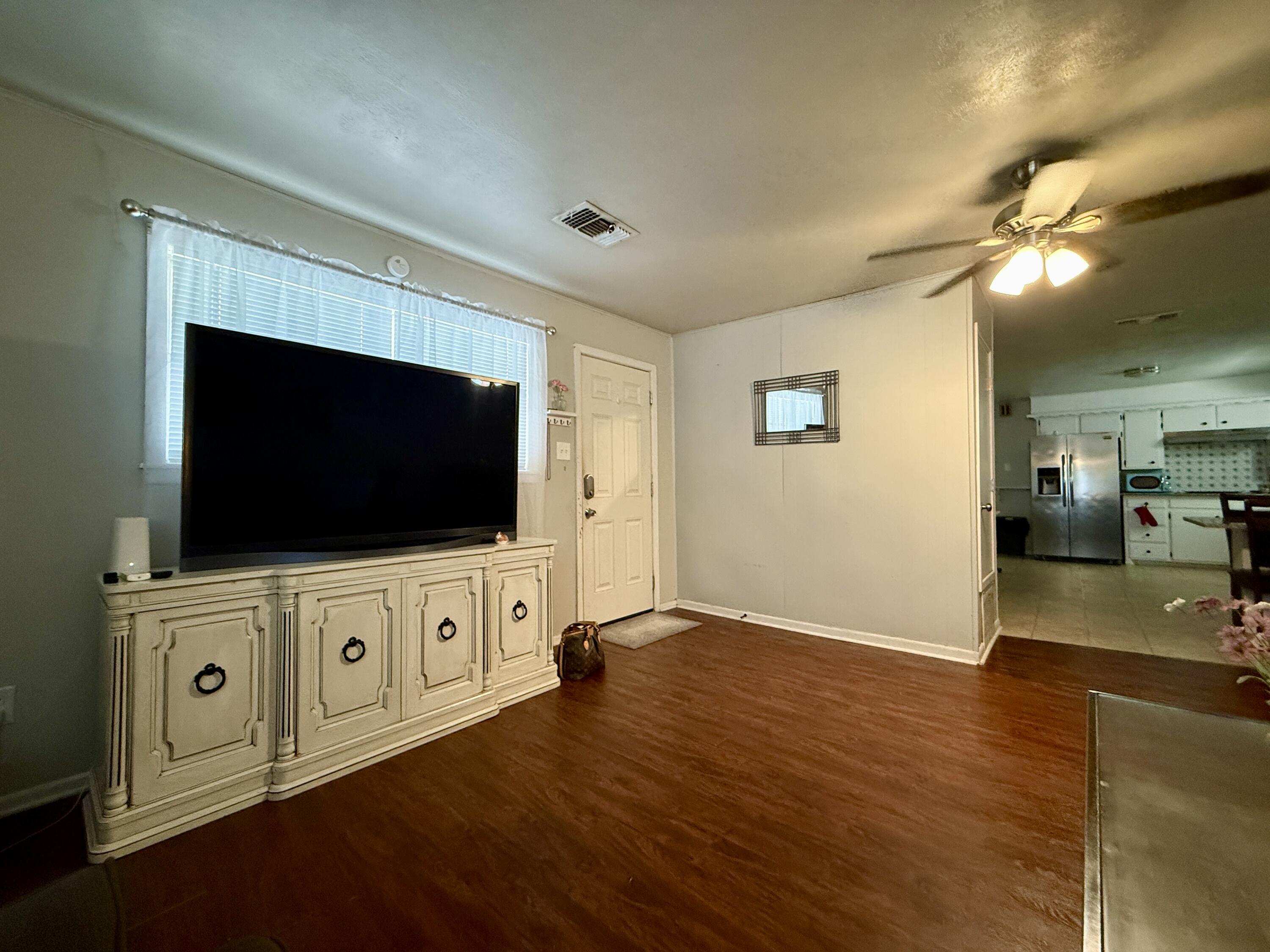 2214 40th Street Lubbock, TX 79412 - Photo 16 of 58 a living room with flat screen tv and kitchen view