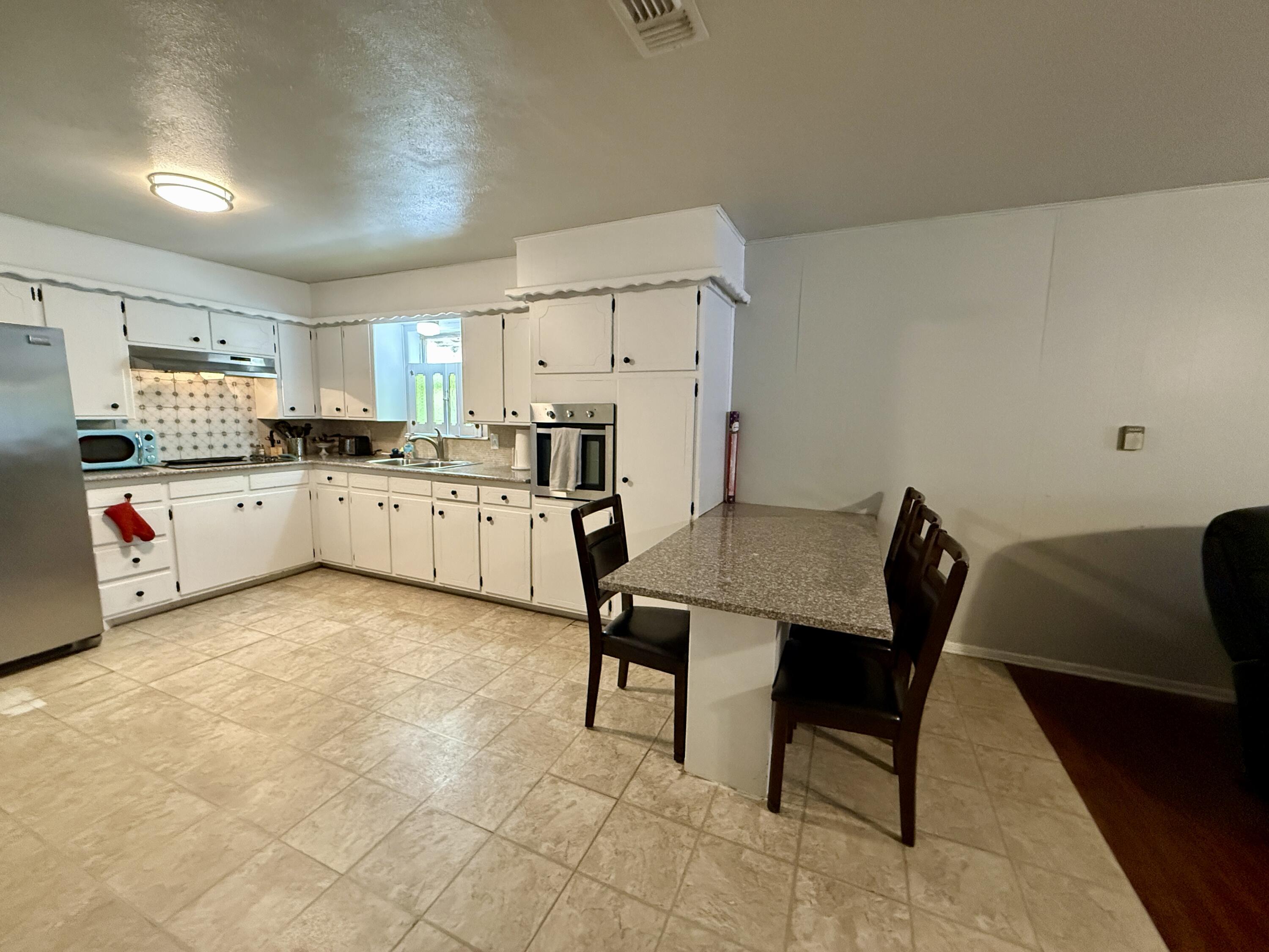 2214 40th Street Lubbock, TX 79412 - Photo 17 of 58 a kitchen with white cabinets and white appliances