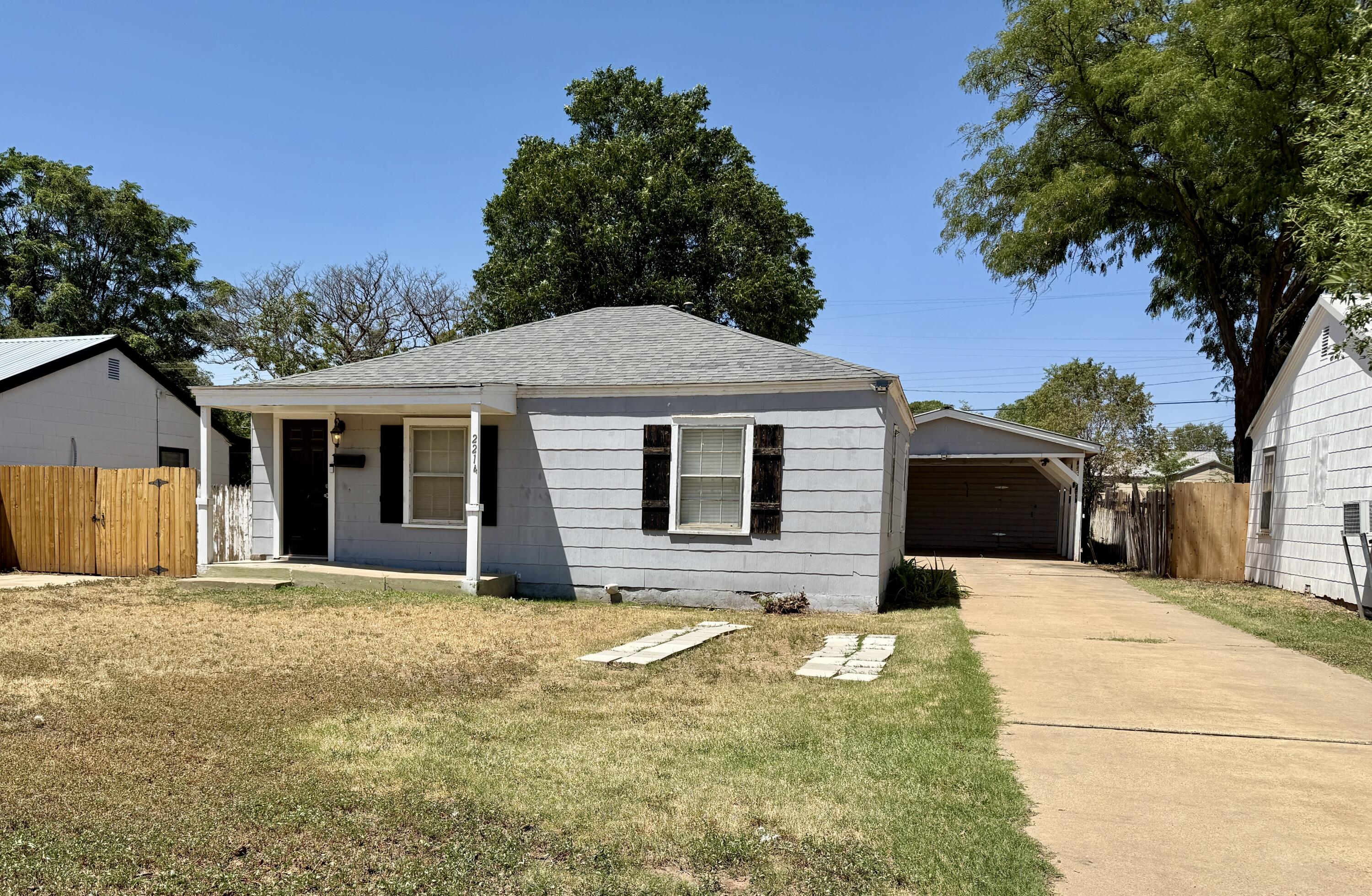 2214 40th Street Lubbock, TX 79412 - Photo 2 of 58 a front view of house with yard and trees in the background