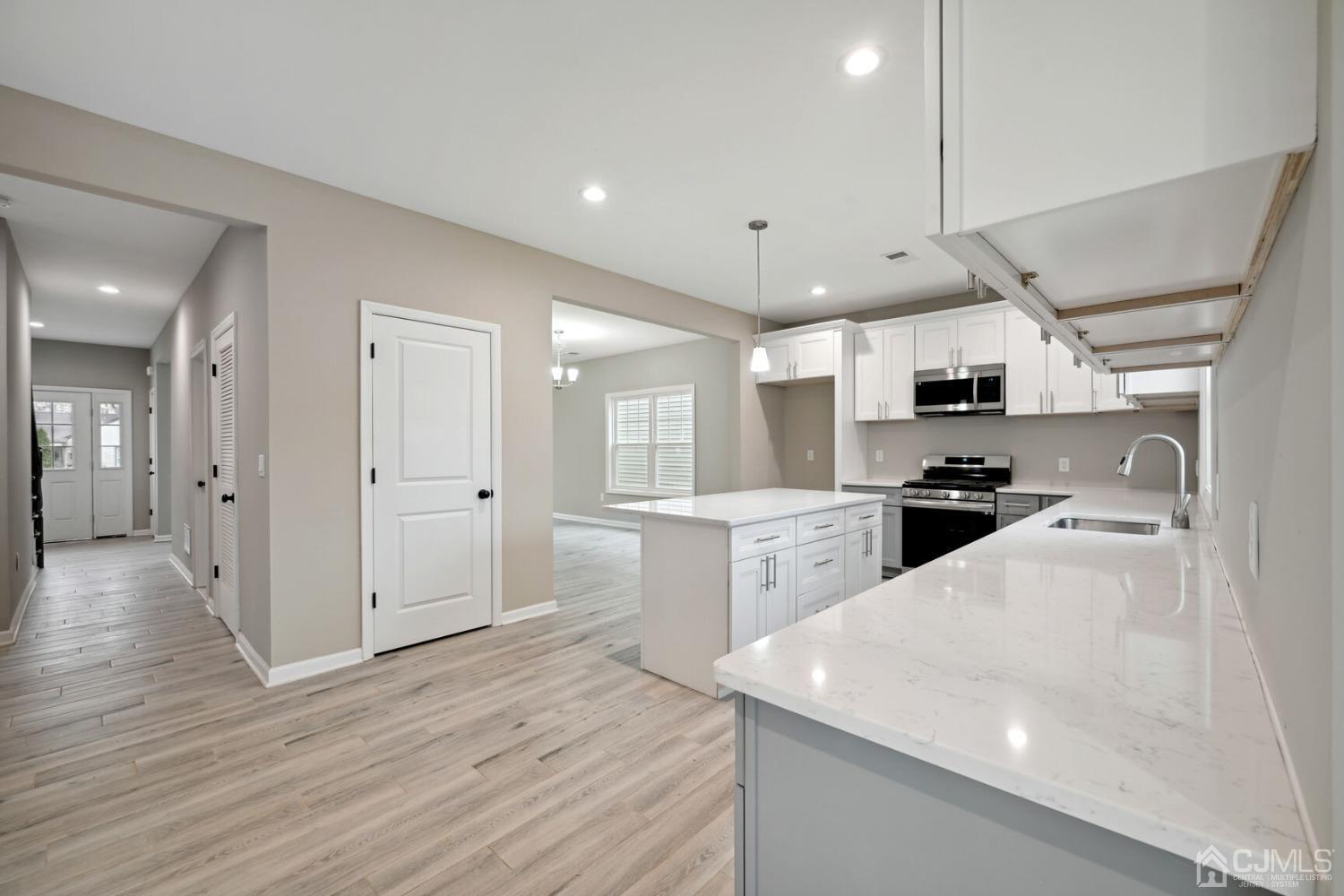66 Runyon Avenue Edison, NJ 08817 - Photo 16 of 34 a kitchen with stainless steel appliances kitchen island granite countertop a refrigerator a sink a stove and white cabinets with wooden floor