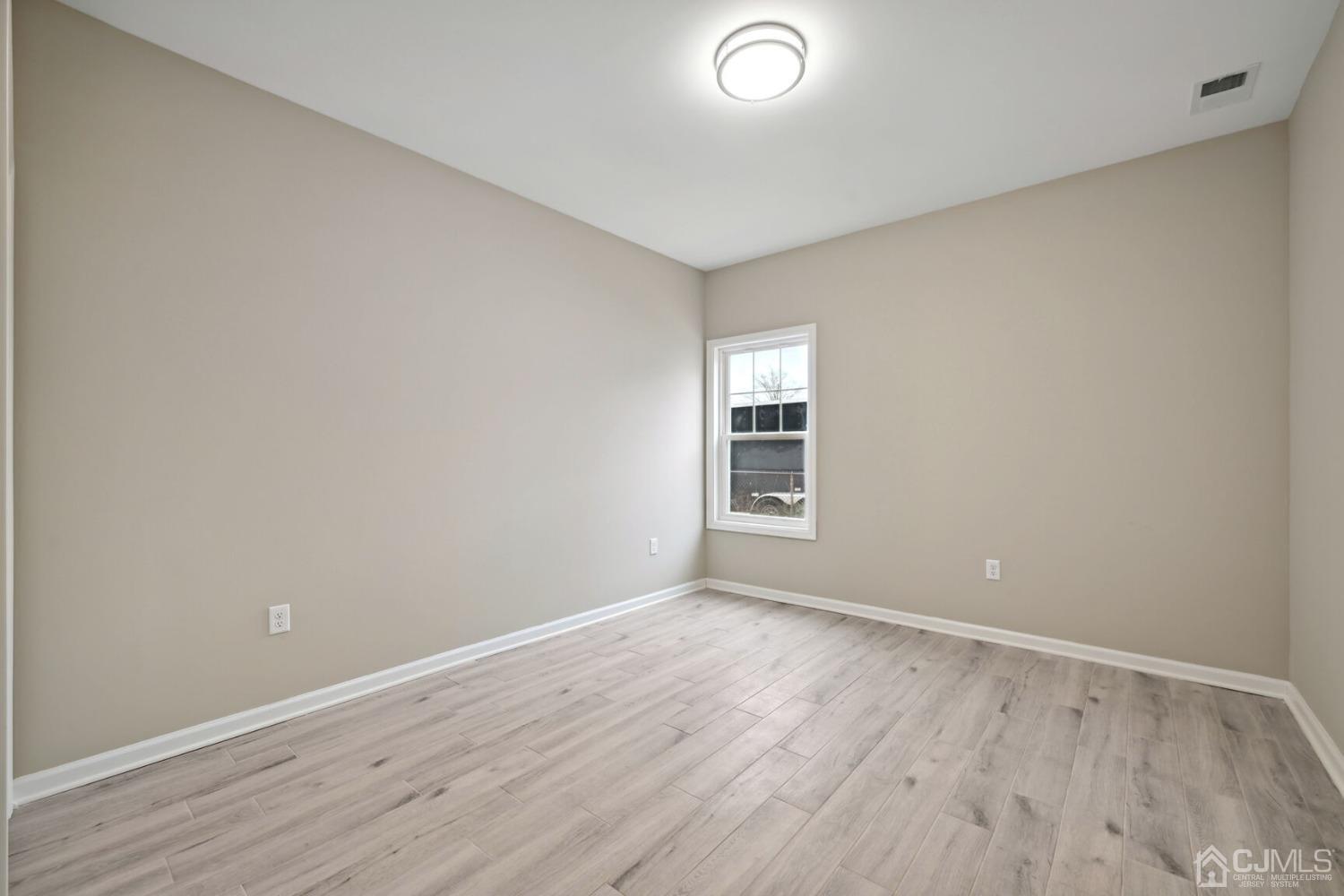 66 Runyon Avenue Edison, NJ 08817 - Photo 23 of 34 an empty room with wooden floor and windows