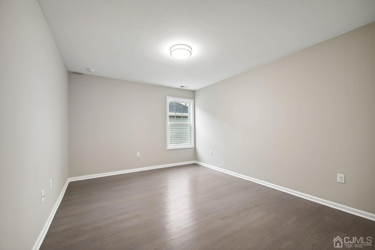 66 Runyon Avenue Edison, NJ 08817 - Photo 28 of 34 an empty room with wooden floor and windows