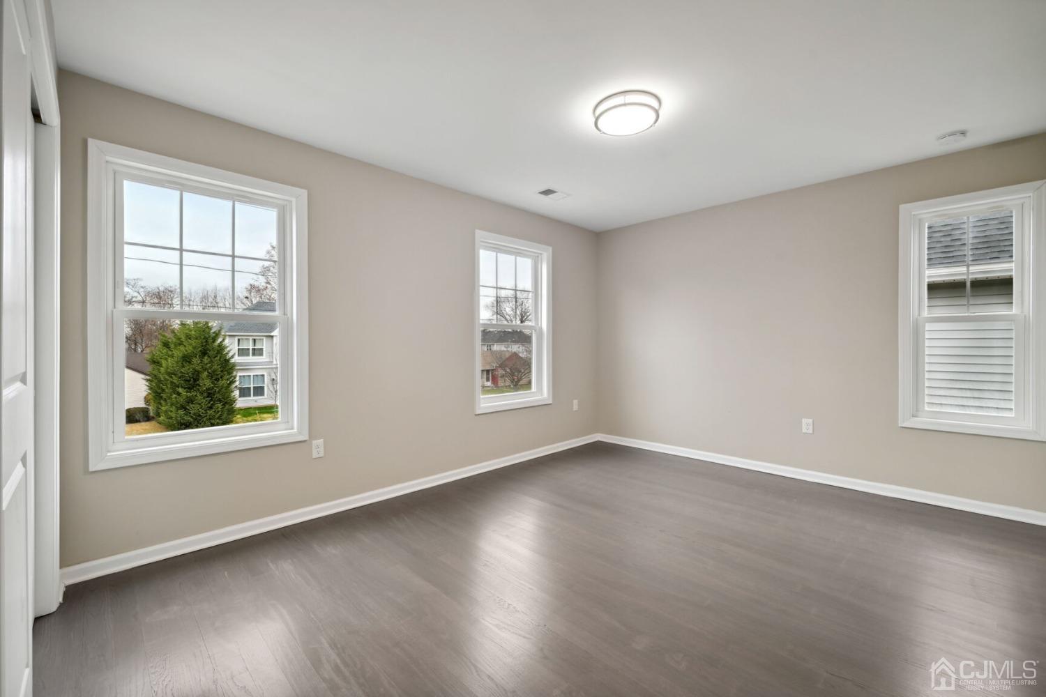 66 Runyon Avenue Edison, NJ 08817 - Photo 29 of 34 an empty room with wooden floor and windows