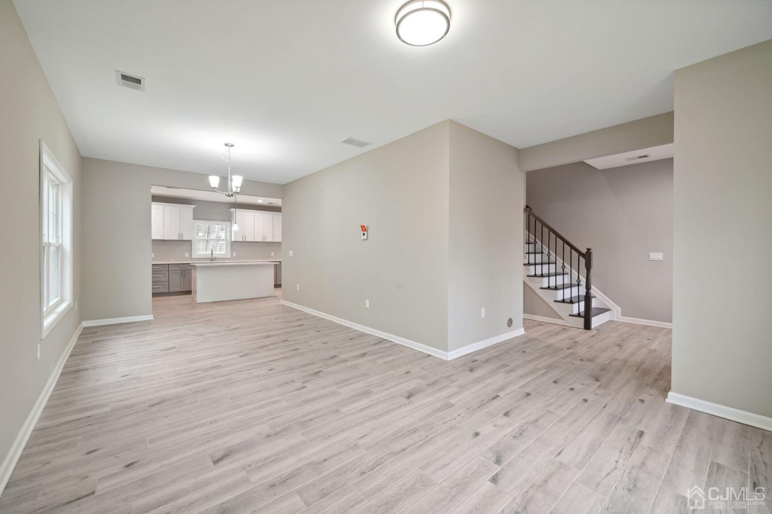 66 Runyon Avenue Edison, NJ 08817 - Photo 7 of 34 a view of empty room with wooden floor and kitchen