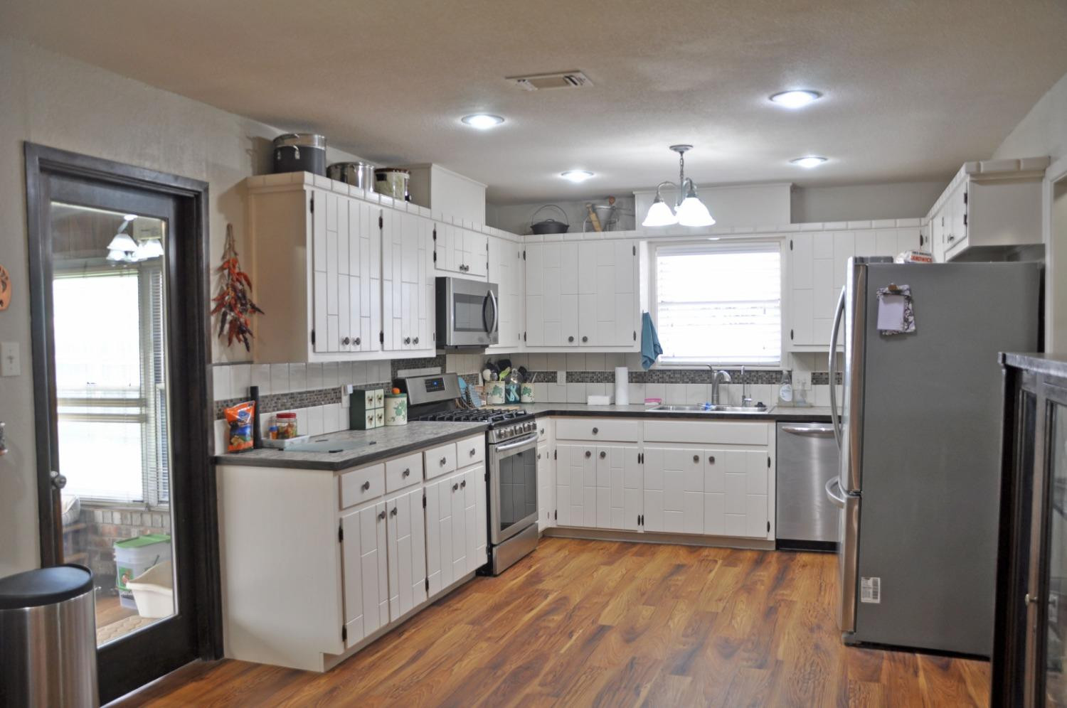 1511 Ave J Abernathy, TX 79311 - Photo 7 of 24 a kitchen with a sink a refrigerator a window and cabinets