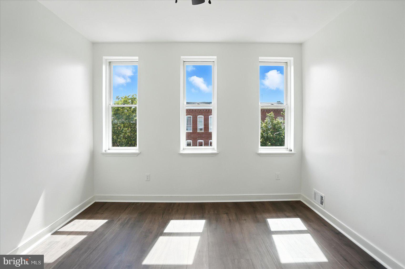 416 Mosher Street Baltimore, MD 21217 - Photo 30 of 38 an empty room with wooden floor and windows