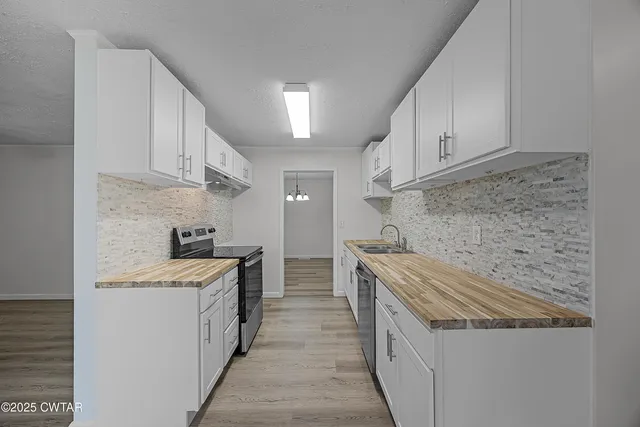 a kitchen with stainless steel appliances granite countertop a sink stove and cabinets