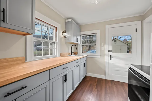 a kitchen with granite countertop white cabinets and wooden floor