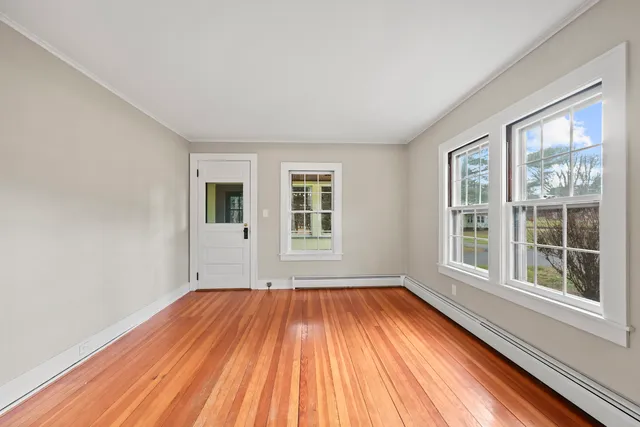a view of a room with wooden floor and windows