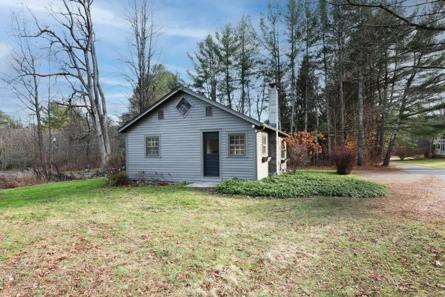 a view of a house with a yard and pathway