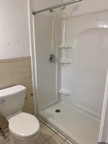 a white toilet sitting next to a bath tub