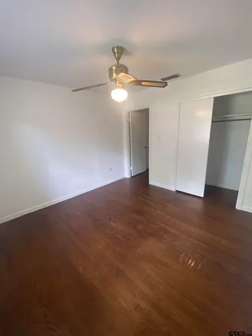 a view of an empty room with wooden floor