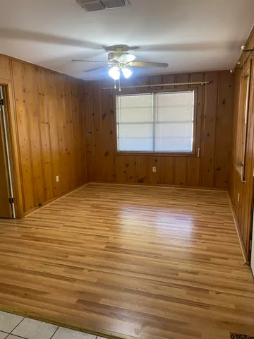 a view of empty room with window and wooden floor