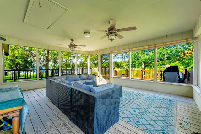 a view of a patio with a table chairs potted plants and wooden floor