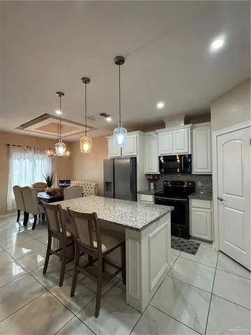 a kitchen with a dining table chairs and white cabinets