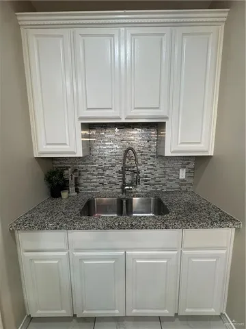 a kitchen with white cabinets and a sink