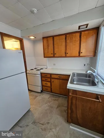 a kitchen with a sink a stove and a refrigerator