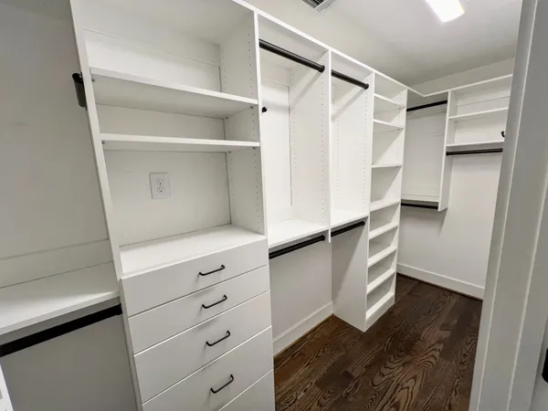 a view of walk in closet with empty racks