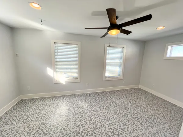 a view of an empty room with window and cabinet area