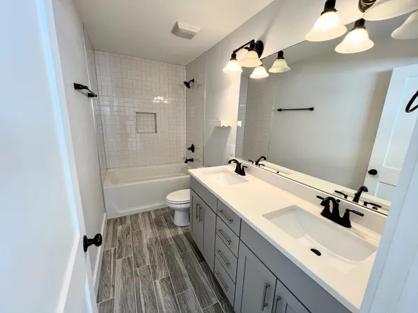 a bathroom with a sink a toilet and a mirror