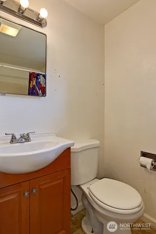 a bathroom with a toilet a sink and mirror