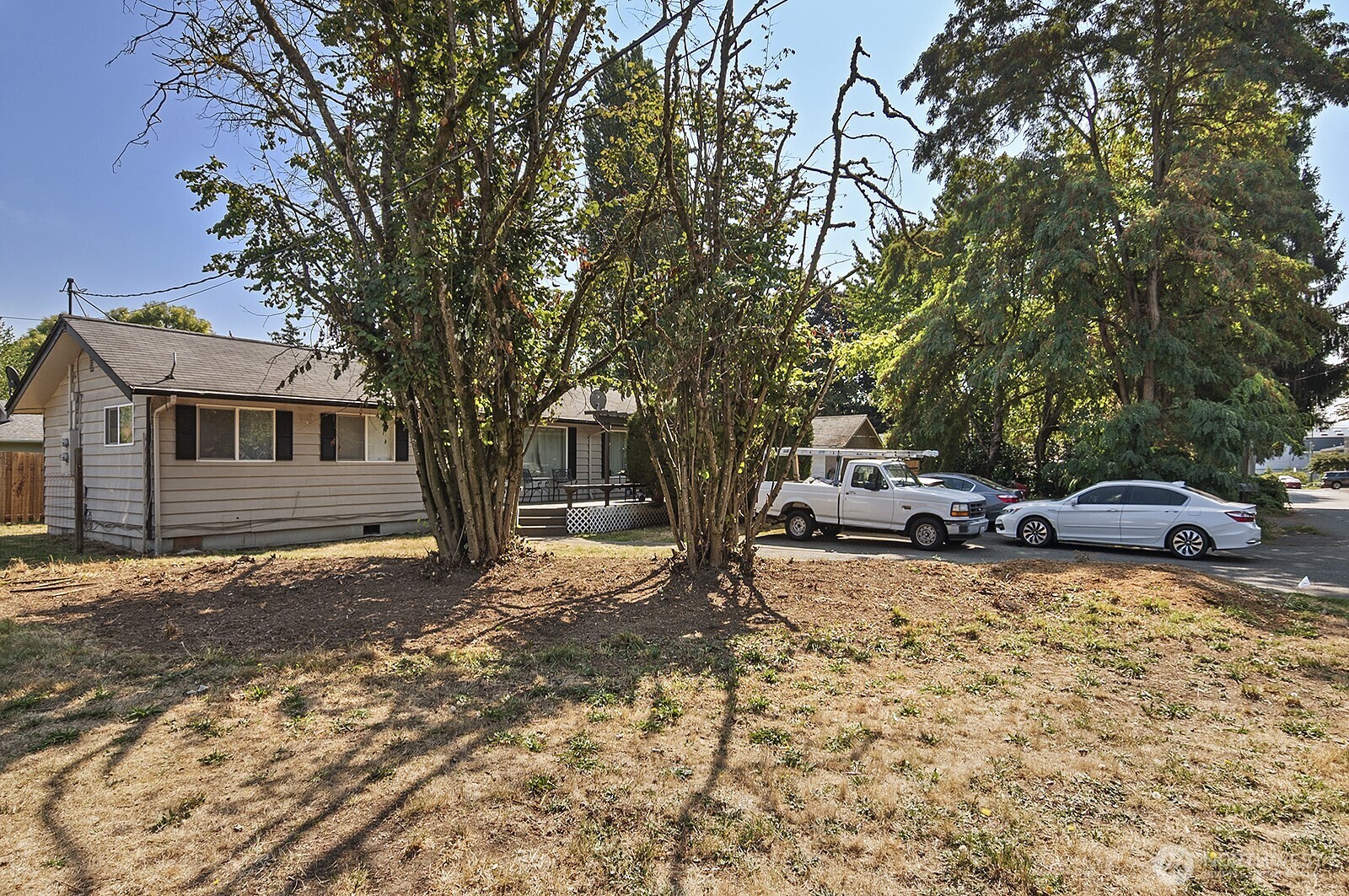 15002 4th Avenue South Burien, WA 98148 - Photo 2 of 30 a view of a backyard with a table and chairs under a large tree