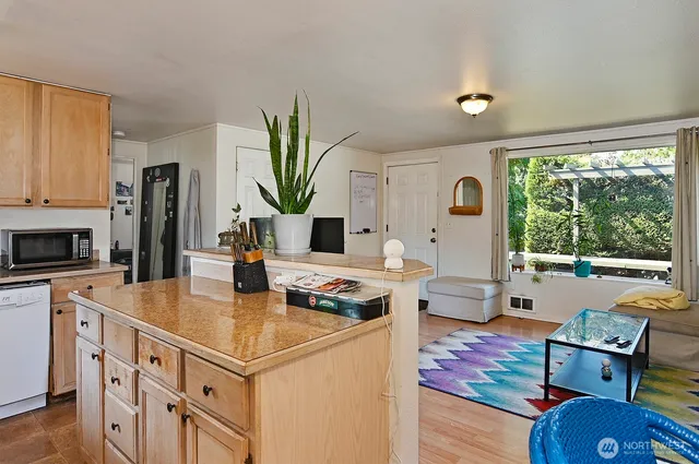 a living room with furniture a large window with kitchen view