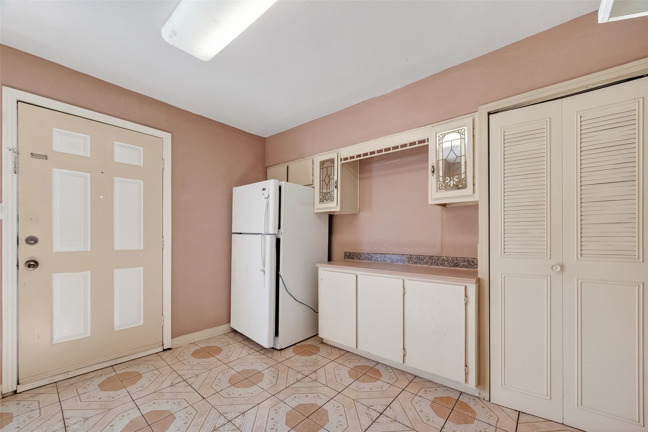 968 Garapan Street Houston, TX 77091 - Photo 14 of 40 a kitchen with white cabinets and refrigerator