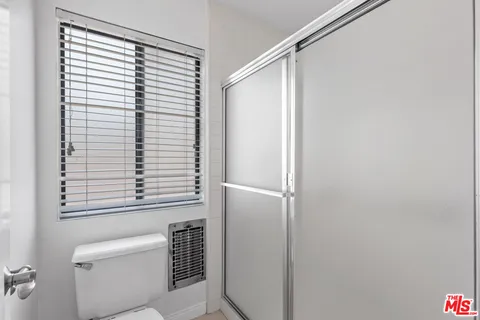 a bathroom with a window and a shower