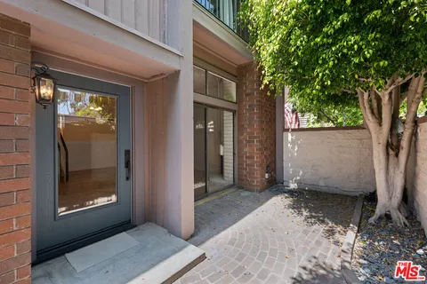 a view of backyard with front door and wooden floor