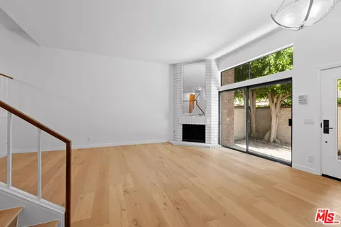 a view of an empty room with a fireplace and a window