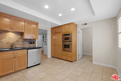 a kitchen with granite countertop a sink and cabinets
